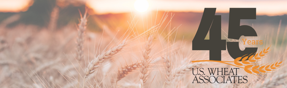 Image shows a wheat field in the setting sun with a graphic showing 45 Years and the U.S. Wheat Associates logo.