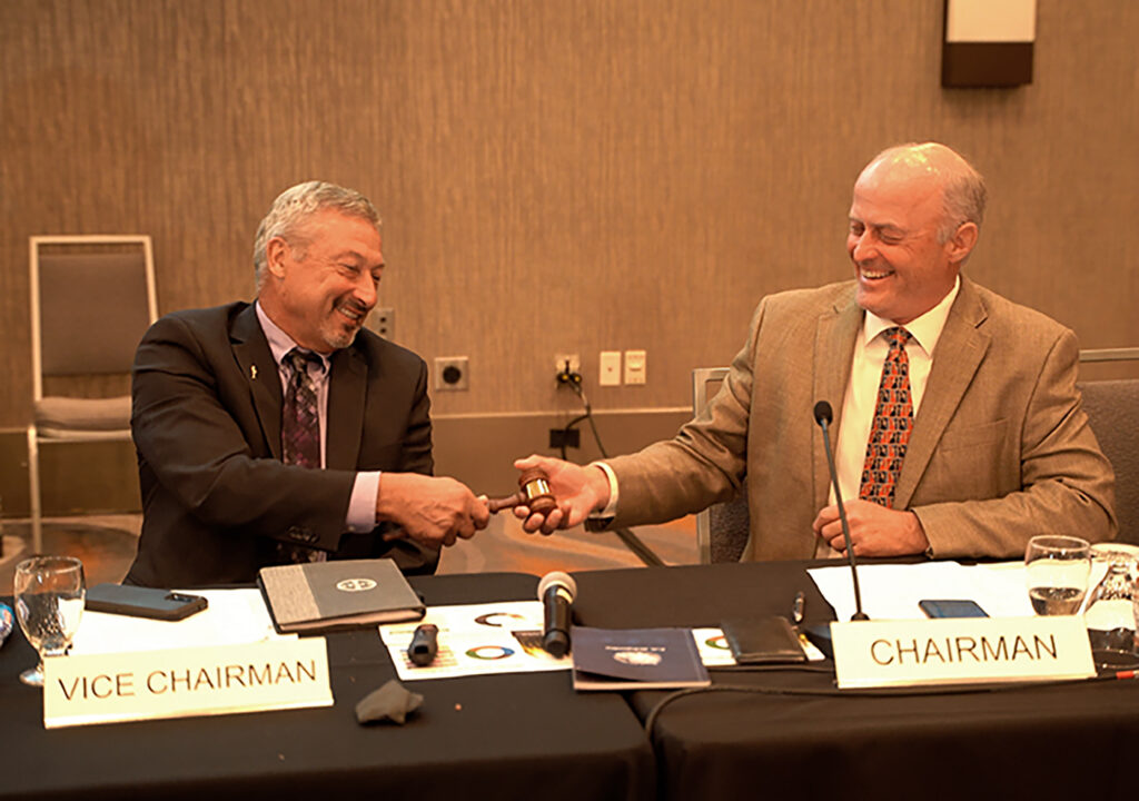 North Dakota farmer Jim Pellman, right, hands the Chairman's gavel to Millershaski during the USW Board of Directors meeting in Fargo. Pellman will serve as Past Chairman for the next year.