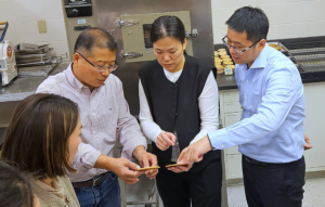 Four people examine test cookies made with soft red winter wheat flour at the ARS Soft Wheat Quality Lab in Wooster, Ohio.