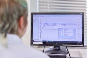 Image shows a laboratory worker viewing a computer screen with a graph from a farinograph test of wheat.