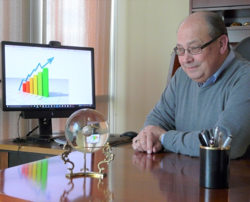 Photo shows Vince Peterson at his desk observing a crystal ball in front of a computer monitor.